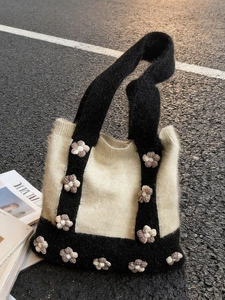Knitted shoulder tote bag with floral accents and contrast black and white design