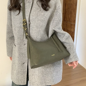 Close-up of olive green leather shoulder bag with gold buckle on adjustable strap