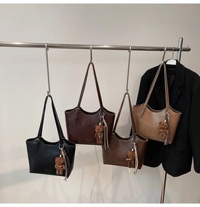 Detail showing four vintage PU leather tote bags in various colors with cute bear charms