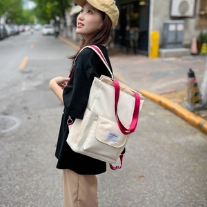 Détail du sac à dos en toile avec sangles rouges et étiquette mode en ville
