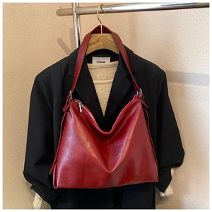 Vintage σκούρα κόκκινη τσάντα tote με φινίρισμα λαδιού-κεριού φορεμένη σε σακάκι