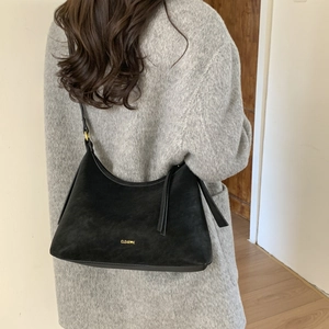 Detail of black suede hobo bag featuring gold CLEAR K logo and adjustable strap buckle