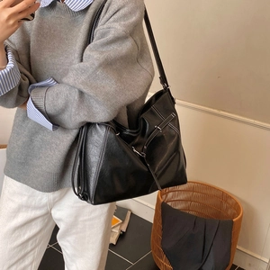 Detail der schwarzen PU-Tasche mit weißen Kontrastnähten und verstellbarer Schnalle