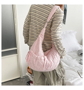 Detailed back view of pink quilted puffer shoulder bag with heart pattern texture