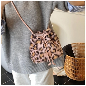 Detail of plush pink leopard print bucket bag with drawstring and cute bow decoration