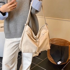 Detailansicht der cremefarbenen Leder-Tote-Bag mit langen Schultergurten und Metallschnalle