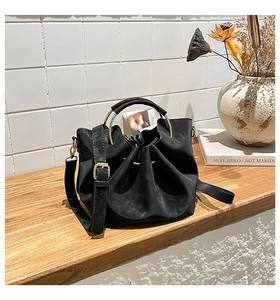 Détail du sac seau noir mat avec poignée en anneau doré et fermeture à cordon de serrage