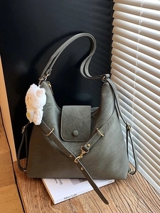 Olive green pebbled leather tote bag with gold hardware and plush bear charm decoration
