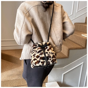 Detailed view of leopard print faux fur bucket bag on model for winter styling