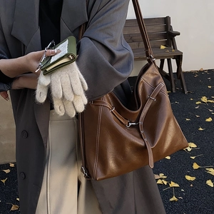 Detailaufnahme der dunkelbraunen Leder-Shopper mit Kontrastnaht und silberner Metallschnalle