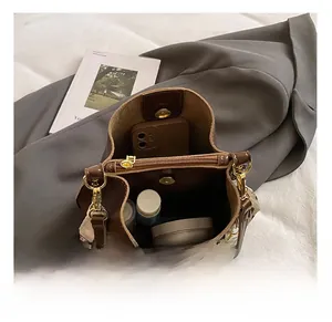 Top view of spacious interior of brown leather bucket bag showing compartments and items