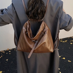 Detailansicht des dunkelbraunen Lederrucksacks mit weißen Nähten an einer Schulter