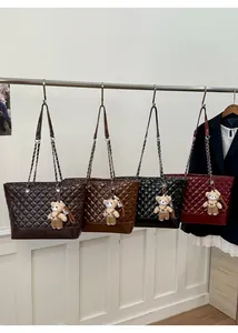 Detail of large quilted tote bags in four colors with chain straps and bear charms