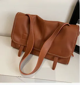 Detail view of brown vintage messenger bag with rectangle flap and dual shoulder straps