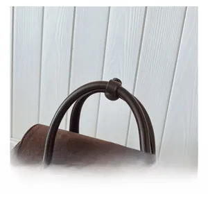 Détails de la texture en daim marron foncé et de la poignée en cuir de ce sac à main
