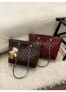 Close-up of quilted chain tote bags in coffee and burgundy with bear charms