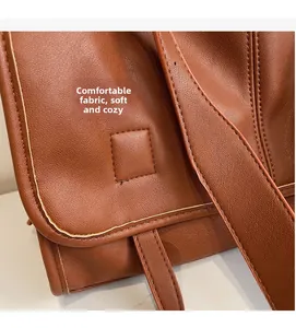Detail showing the brown vintage leather texture and wide strap of the shoulder bag