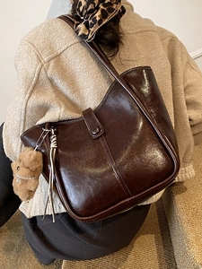 Retro dark brown bucket bag with plush bear charm and tassel for women on shoulder