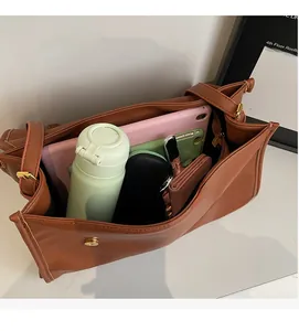Top view showing the spacious interior of this brown vintage messenger bag with daily items