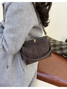 Detail view of retro brown doctor bag with metal clasp and frosted leather texture