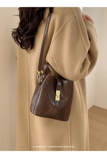 Vue détaillée d'un sac seau marron rétro avec un fermoir rotatif doré et une bandoulière
