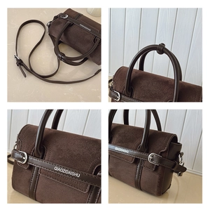 Détail en daim marron foncé et cuir avec boucle argentée et logo de la marque