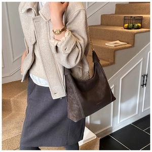 Detail of dark brown suede Hobo bag with white contrast stitching and chain strap