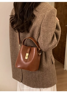 Retro brown leather bucket bag styled with a warm wool coat for a winter aesthetic