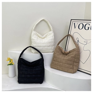 Gros plan détaillé de sacs hobo matelassés en blanc, noir et marron avec surpiqûres