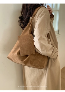 Detail of a brown suede tote bag featuring a matching small zipper pouch attachment