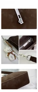 Detailed view of dark brown suede shoulder bag with G-shaped silver buckle and bear charm