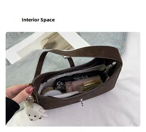 Interior space of the brown leather shoulder bag showing cosmetics and a wallet