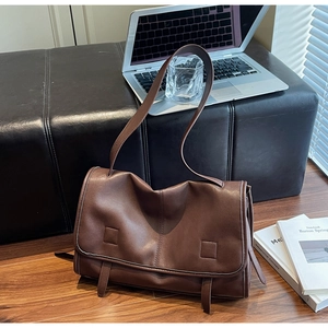 Close-up of vintage brown leather satchel with dual strap detail and flap closure