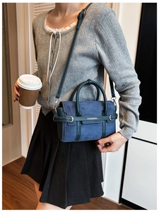 Détail du sac bandoulière en daim bleu prussien avec sangle à boucle et poignées de main
