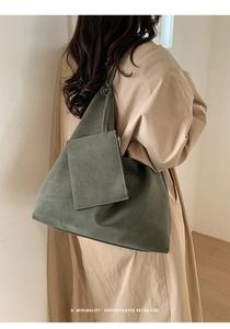 Model wearing dark green retro tote bag with matching small coin pouch detail