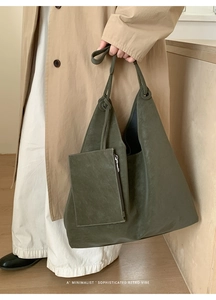Deep olive green tote bag with matching pouch shown in a minimalist lifestyle setting