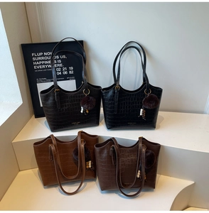 Detail of crocodile pattern leather bucket bags with faux fur balls in four classic colors