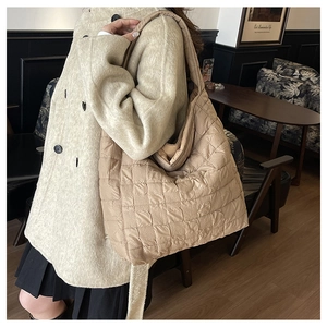 Vue détaillée du grand sac cabas matelassé beige avec texture carrée et bandoulière