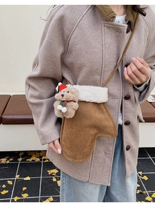Detailansicht der braunen Wildledertasche mit weißem Fleece und süßem Plüschbär-Anhänger