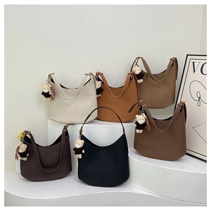 Détail de sacs hobo vintage en six tons terre avec pendentif d'ours charmant