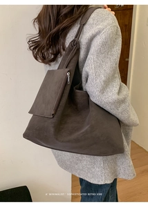 Detail of dark brown retro tote bag with smooth faux leather texture and outer pouch