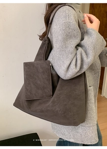 Detail of dark brown matte suede tote bag with small attached zipper pouch for accessories