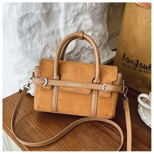 Gros plan d'un sac bandoulière vintage marron avec poignées rondes et détails raffinés