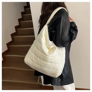 Vue détaillée d'un grand sac cabas blanc matelassé avec texture à carreaux portés