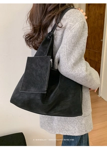 Detail view of large black suede tote bag with a small matching zip pouch accessory