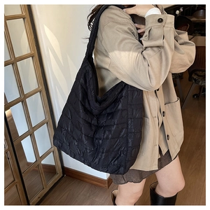 Détail du grand sac cabas noir matelassé en nylon avec motif de losanges et design chic