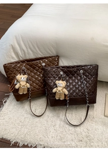 Close-up of quilted tote bags in brown and coffee faux leather with chain straps
