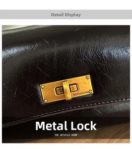 Macro shot of vintage gold hardware lock on dark oil wax leather crossbody bag