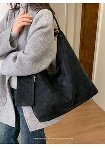Detail of minimalist black hobo tote bag with matching zippered pouch and wide strap