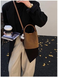Retro faux suede bucket bag in brown and black stitching detail shown in street style